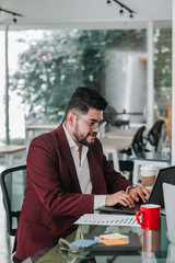 Latin american man with beard working at computer at  office in Mexico