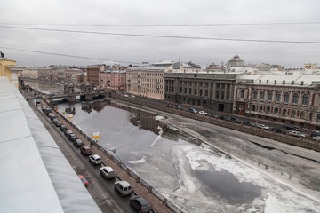 Wall Mural - Winter cityscape of St. Petersburg with the freezing Fontanka river and a view of the Lomonosov bridge