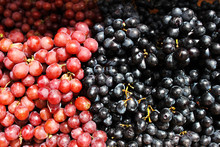 Two Varieties Of Grapes, Pink And Black On The Market Counter. Grapes At The Farmers ' Market. Grapes For Making Wine.