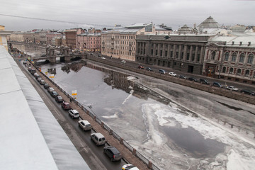 Wall Mural - Winter cityscape of St. Petersburg with the freezing Fontanka river and a view of the Lomonosov bridge