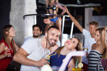  Happy cheerful positive man and woman dancing and hugging on party in the club