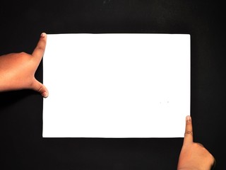 Wall Mural - Hand holding white paper isolated on black background. Close-up hand holding blank sheet