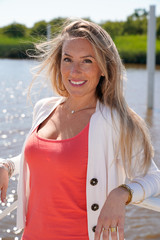 Wall Mural - cheerful woman smiling happiness enjoying summer vacation near seaside hair in wind