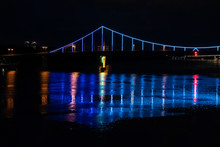 Night View Of A Beautiful Multi-colored Illumination On The Bridge. Reflection In The River
