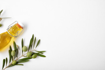 Wall Mural - Bottle with oil and olive twig on white table top