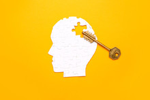 Human Head Made Of Puzzle Pieces And Key On Color Background