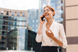 © uladzislaulineu - Young woman businesswoman talking on the phone on the background of the business center