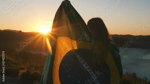 Fotografía Brazilian Girl with National Flag at sunrise