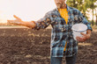 © LIGHTFIELD STUDIOS - cropped view of farmer in checkered shirt sowing seeds on plowed field