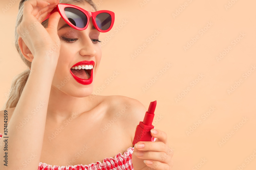 Beautiful young woman with lipstick on color background