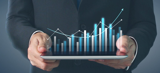  Plan graph growth and increase of chart positive indicators, tablet in hand