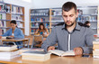 © JackF - Serious young guy student searching for information in books in university library