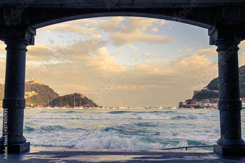 Fotografía first lights of day in the arcades of la cocha beach in san sebastian, spain