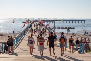 Palanga. Resort on the Baltic Sea. Sun and sea. Summer vacation at sea. People are walking. Long pier far out to sea. Bridge. Walking to the shore of the sea. Restful life. Blue water. Sand beach