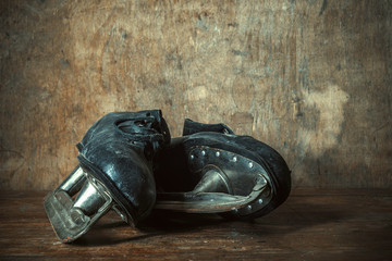 Old black leather skates on a wooden table in a retro style