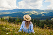© maryviolet - Traveling in summer Ukraine. Trip to Carpathian mountains. Woman tourist relaxing in flowers admiring view