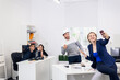 © Anna Kosolapova - Employees having fun in the office, posing and taking selfies with a smartphone.