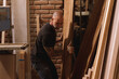 Hombre maduro mexicano trabajando carpintero en taller con madera tabla sierra martillo 