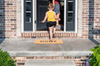 © Kristen - Barefoot little girl entering the front door of a home with a welcome mat that says Feels Good to be Home