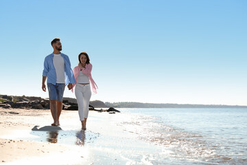 Poster - Happy young couple walking on beach near sea. Honeymoon trip