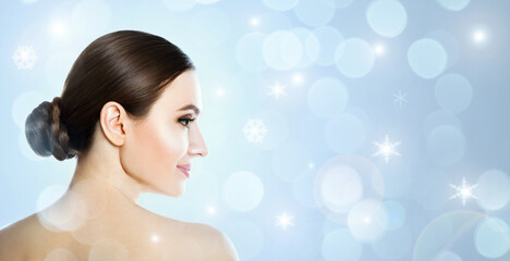 Poster - Young woman with perfect smooth skin on light blue background, bokeh effect. Space for text