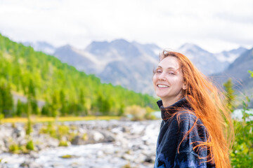 Portrait of a happy woman on the background of mountains and multinsky lake