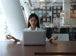 © bongkarn - Portrait of female office worker meditating in meeting room