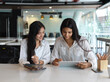 © bongkarn - Portrait of two female college students preparing their presentation on digital tablet