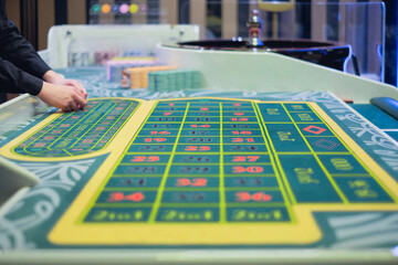 Green casino table, roulette with colored chips, ready to play
