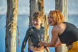 A mother puts natural mineral mud on her son's body in a salt lake . Concept of health-improving children's recreation .