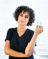 young caucasian woman manicurist master with nail tools is smiling on the white background