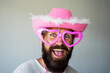 Happy man smile face. Handsome smiling young guy with funny pink glasses. Positive human facial expressions and emotions.