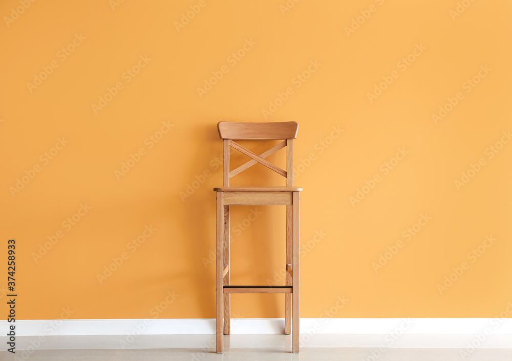Wooden chair near color wall
