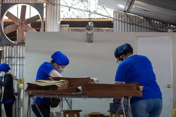 dos trabajadoras laborando en una fábrica de imprenta