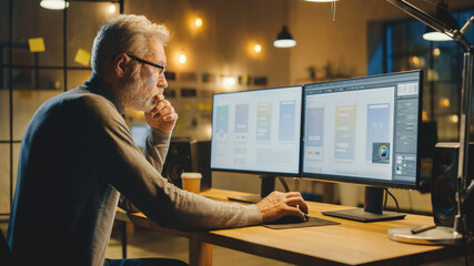 Poster - Creative Middle Aged Mobile Software Designer Sitting at His Desk Uses Desktop Computer with Two Screens Showing Smartphone Application Design Process. Stylish Modern Studio Office