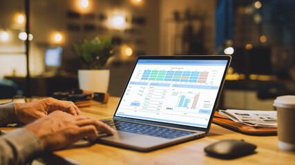 Aufkleber - Close-up On the Hands of the Male Specialist Works on a Laptop Computer, Screen Shows Various Data and Statistics. In the Background Evening in the Stylish Studio Office