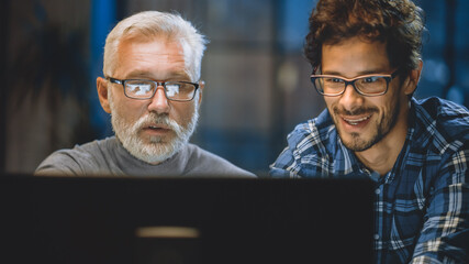 Poster - Chief Creative Designer Shows Desktop Computer Screen to a Young Developer, They Discuss Project. Two Professionals Having Discussion. Choosing Right Design Concept. Evening in the Studio Office