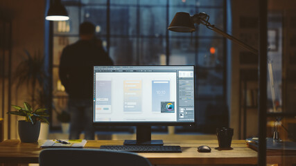 Poster - Shot of a Desktop Computer in the Office Shows Screen with Mobile Phone Application Design, Software UI Development. In the Background Designer Drinks from a Cup Looks at the Night City out of Window.