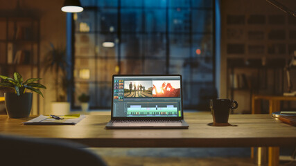 Aufkleber - Shot of a Laptop Computer Standing on a Desk with Professional Video Montage Editing Software. In the Background Warm Evening Lighting and Open Space Studio with City Window View.