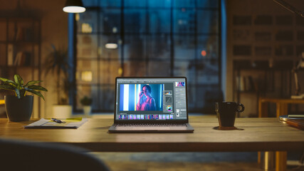 Poster - Shot of a Laptop Computer in the Modern Office Showing Photo Editing Software. In the Background Warm Evening Lighting and Open Space Studio with City Window View