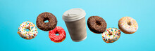 Donuts Flying In The Air And Coffee Paper Cup On A Blue Background. Bakery, Baking Concept. Levitation. Banner
