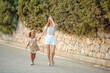 © lialia699 - Mother and daughter walking in park during hot summer day. Family time outdoor.