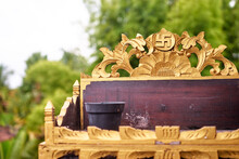 Golden Coloured And Highly Decorated Stand With Ancient Symbol At The Center Of It.