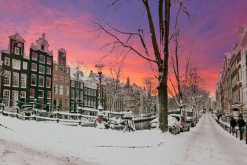 Poster - City scenic from snowy Amsterdam in the Netherlands at sunset