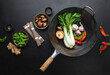 Asian culinary ingredients with wok on a dark surface