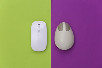 Wall Mural - Old and modern pc mouse on purple green background. Top view