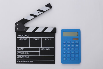 Wall Mural - Movie clapper board and calculator on white background. Cinema fees. Filmmaking, Movie production. Top view