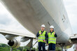 © ake1150 - Asian man and woman engineer maintenance airplane thumb up and holding wrench in front airplane from repairs, fixes, modernization and renovation in airport..