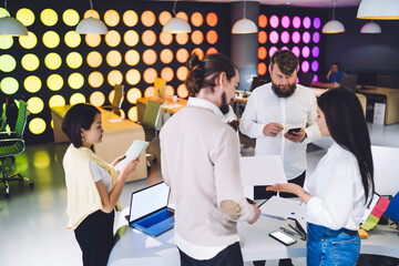 Wall Mural - Diverse group of coworkers discussing project in creative workspace