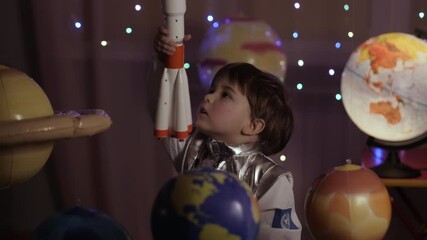 Wall Mural - Space Travel Game Inspiration Spaceship. Little Kid Boy Astronaut Launching Toy Rocket From Spaceport Through Planets. Child Dreamer Playing With Toy Space Rocket Flying Among Planets. SLOW MOTION.